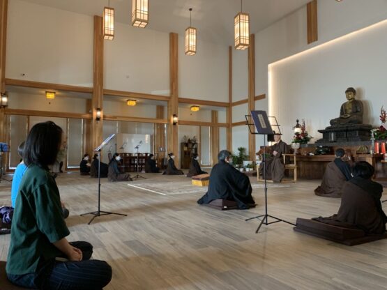 People meditating near a Buddha statue