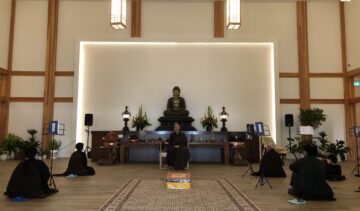 People meditating before a Buddha statue