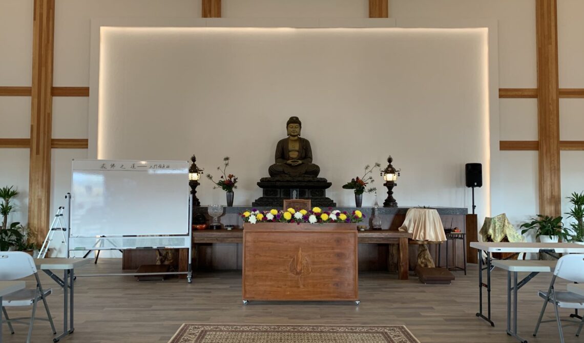 Buddhist altar with statue and flowers